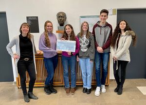 Vertreterinnen und Vertreter der Klasse 9a übergeben stolz ihre Spende an Corinna Rollinger zur Weiterleitung nach Südafrika